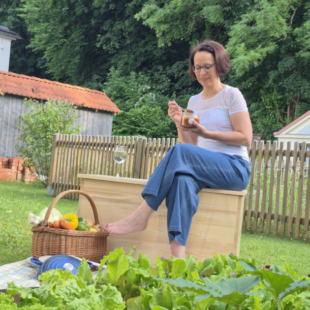 Frau im Garten auch Kochkiste sitzend